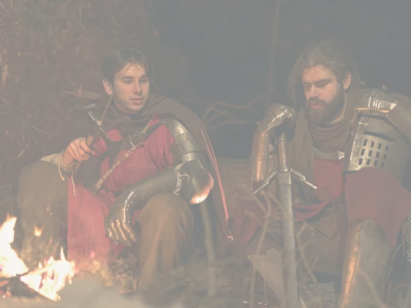 feature teaser showing two guys talking around a campfire, fantasy vibes